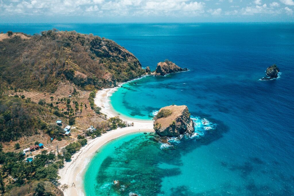 Pantai Koka Sulawesi Tenggara - pemandangan pantai pasir pink yang masih alami dengan air laut biru jernih dan vegetasi hijau